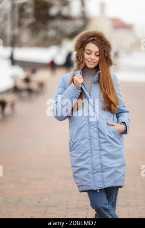 une jeune femme marche dans le parc d'hiver. Parc d'hiver dans la neige. Vêtements publicité photo concept Banque D'Images