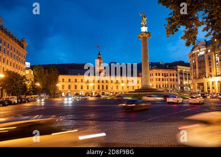 Scène nocturne de la circulation encerclant la statue de Saint-Georges sur la place de la liberté (place de la liberté) à Tbilissi, Géorgie, Caucase, Europe de l'est. Banque D'Images