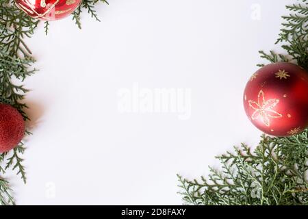 Composition de cadre naturelle avec branches en sapin de Noël et décoration de boule rouge sur fond blanc.mise en page d'espace de copie créative.pose à plat,vue du dessus. Banque D'Images