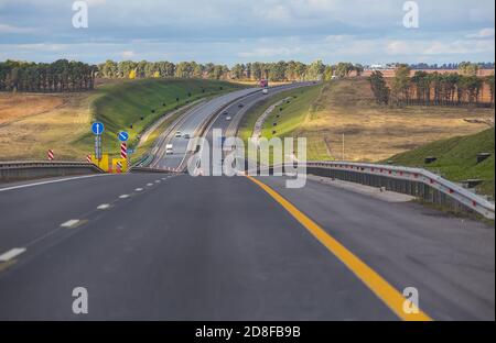 Nouvelle autoroute de banlieue dans une zone vallonnée au virage Banque D'Images