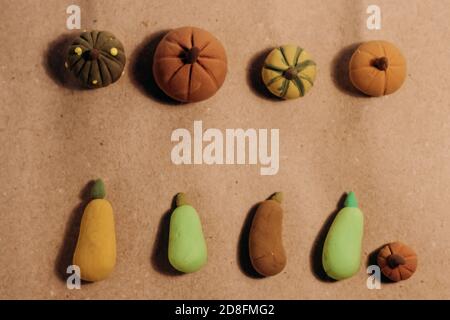 De jolies citrouilles artisanales miniatures étapissent sur du papier brun artisanal. Banque D'Images