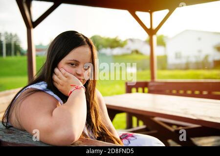Un portrait de trisomie 21 adulte fille dehors au coucher du soleil Banque D'Images
