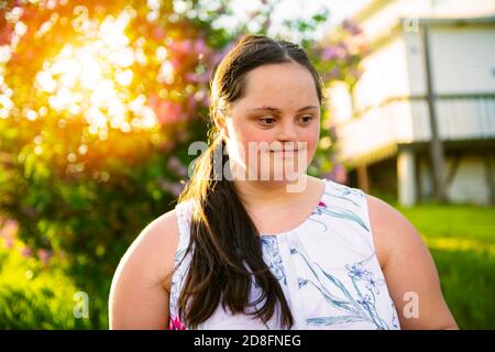 Un portrait de trisomie 21 adulte fille dehors au coucher du soleil Banque D'Images