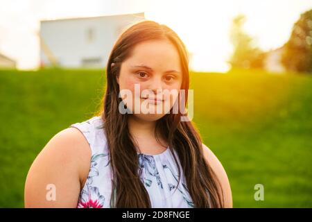 Un portrait de trisomie 21 adulte fille dehors au coucher du soleil Banque D'Images