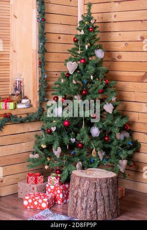 Un coin joliment décoré d'une maison en bois avec Noël arbre décoré et cadeaux Banque D'Images