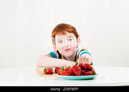 un enfant atteint pour les fraises Banque D'Images