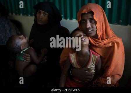 Rohingya femmes dans un centre psychologique tient son enfant dans ses bras. Camp de réfugiés de Kutupalong au Bangladesh. Plus de 650,000 Rohingya ont traversé la frontière avec le Bangladesh depuis août de l'année dernière, fuyant la violence. Banque D'Images