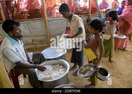 Les réfugiés de Rohingya ont reçu de la nourriture au centre de transit de Kutupalong. Plus de 650,000 Rohingya ont traversé la frontière avec le Bangladesh depuis août de l'année dernière, fuyant la violence. Banque D'Images