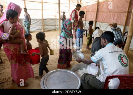 Les réfugiés de Rohingya ont reçu de la nourriture au centre de transit de Kutupalong. Plus de 650,000 Rohingya ont traversé la frontière avec le Bangladesh depuis août de l'année dernière, fuyant la violence. Banque D'Images