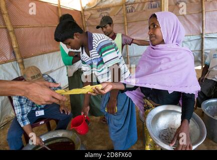 Les réfugiés de Rohingya ont reçu de la nourriture au centre de transit de Kutupalong. Plus de 650,000 Rohingya ont traversé la frontière avec le Bangladesh depuis août de l'année dernière, fuyant la violence. Banque D'Images