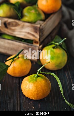 Mandarine avec des feuilles sur un pays à l'ancienne table. Focus sélectif. La verticale. Banque D'Images