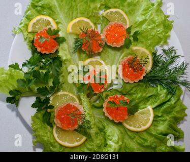Tartelettes avec caviar rouge sur une planche à découper Banque D'Images
