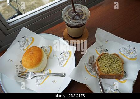 Gros plan sur le donut de brioche à la vanille française et les graines de pavot au citron Gâteau à la livre servi avec du café glacé noir sur une table en bois Banque D'Images