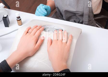 Gros plan photo de la femme assise à la procédure des ongles devant le maître. Banque D'Images