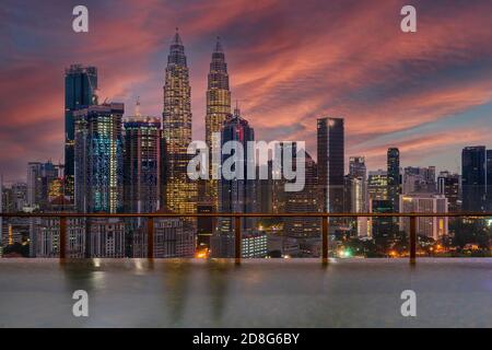 Horizon de la ville avec piscine à débordement au lever du soleil, Kuala Lumpur, Malaisie Banque D'Images