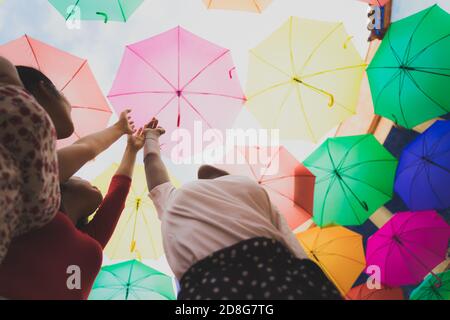 Rêver au premier vol. Les filles prétendant voler, toucher le ciel. Femmes avec parasols multicolores. Concept rêve et amour. Image avec effet de flou Banque D'Images