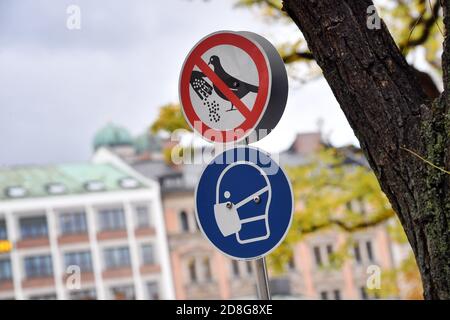 Enseigne de l'obligation de masque sur le Viktualienmarkt à Munich. Au-dessus de lui, un signe est interdit de nourrir les pigeons. Exigence de masque dans les zones piétonnes et les lieux publics de Munich le 27 octobre 2020. | utilisation dans le monde entier Banque D'Images