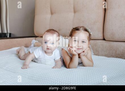 Deux petites filles, sœurs jouant à la maison, sur le canapé, s'embrassant, isolement, vacances, week-end à la maison, socialisation Banque D'Images