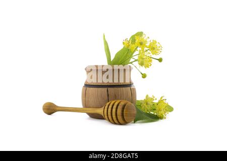 Petit pot en bois de fleurs et de feuilles de tilleul jaune fraîchement cueillies, également appelé tilia et baguette en bois sur fond blanc Banque D'Images