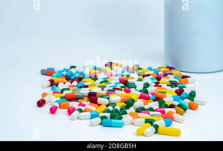 Capsules colorées près d'une bouteille de médicament en plastique. Pilules de capsule multicolores sur table blanche. Pharmacie produits de pharmacie. Industrie pharmaceutique. Banque D'Images