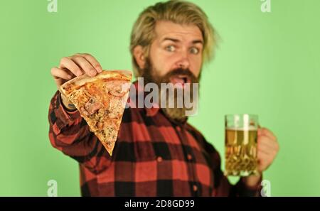 Cuisine gastronomique. Un homme gai barbu hipster tient des pizzas. Parfait repos au pub. Un homme affamé va manger de la pizza et boire de la bière. Enfin la pizza temps. La pizza est meilleure lorsqu'elle est partagée. Pizzeria restaurant. Banque D'Images