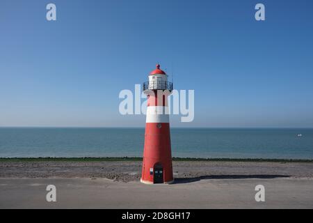 Phare rouge et blanc sur fond bleu ciel, Westkapelle aux pays-Bas. Banque D'Images