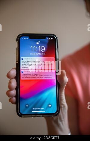 L'image montre: Possible Covid 19 exposition Test complet NHS et application trace montrant des alertes sur le téléphone avec un autre disant de ne pas s'inquiéter. Qui est sa Banque D'Images