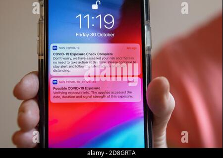 L'image montre: Possible Covid 19 exposition Test complet NHS et application trace montrant des alertes sur le téléphone avec un autre disant de ne pas s'inquiéter. Qui est sa Banque D'Images