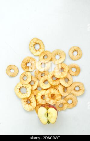 Composition de la couche plate avec des tranches de pommes fraîches et séchées sur fond blanc. En-cas bio végétalien naturel cru. Concept d'alimentation saine. Vue de dessus. Banque D'Images