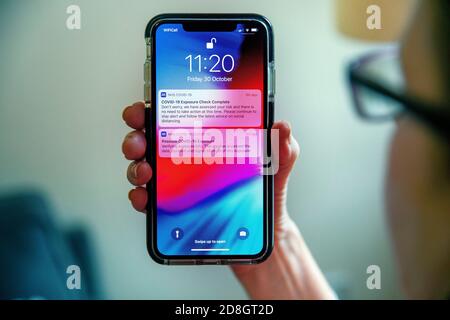 L'image montre: Possible Covid 19 exposition Test complet NHS et application trace montrant des alertes sur le téléphone avec un autre disant de ne pas s'inquiéter. Qui est sa Banque D'Images