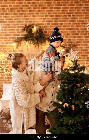 Une chambre familiale jeune et heureuse décorera l'arbre de Noël Banque D'Images