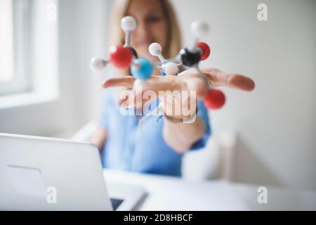 belle jeune femme avec modèle moléculaire dans le bureau moderne Banque D'Images