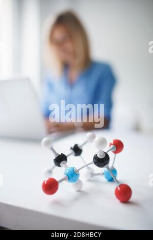 belle jeune femme avec modèle moléculaire dans le bureau moderne Banque D'Images