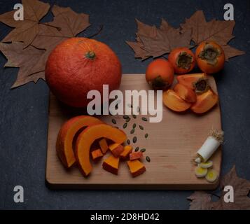 Citrouille, poireaux, kaki, légumes d'automne, fruits aux feuilles brunes d'automne. Banque D'Images