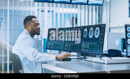 Scientifique médical travaillant avec des images CT Brain Scan sur un ordinateur personnel en laboratoire. Neurologues du Centre de recherche neurologique travaillant sur un Banque D'Images