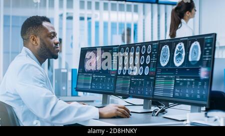 Scientifique médical travaillant avec des images CT Brain Scan sur un ordinateur personnel en laboratoire. Neurologues du Centre de recherche neurologique travaillant sur un Banque D'Images