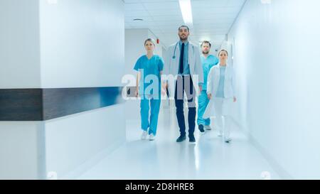 Une équipe de médecins, chirurgiens et infirmières traverse le couloir occupé de l'hôpital, ils parlent de patients, de chirurgies à venir et de sauver des vies. Propre Banque D'Images