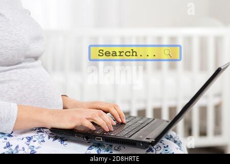 Une femme enceinte utilise un ordinateur portable. Gros plan sur les mains et l'ordinateur portable. Fenêtre de recherche d'informations, le concept des technologies modernes et de la pigiste. Banque D'Images