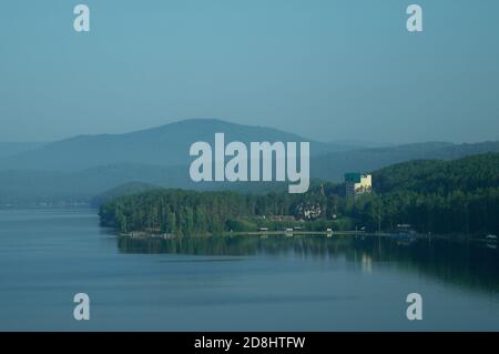 Lac, hôtels, parcs et plages situés sur la rive du lac, entouré de forêts et de montagnes. Banque D'Images