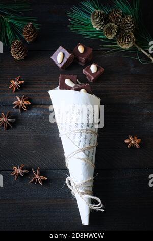 cubes de pain d'épice avec glaçage au chocolat dans un sac en papier, décoré avec une branche de pin, et un emporte-pièce orignal Banque D'Images