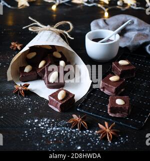 cubes de pain d'épice avec glaçage au chocolat dans un sac en papier, décoré avec une branche de pin, et un emporte-pièce orignal Banque D'Images