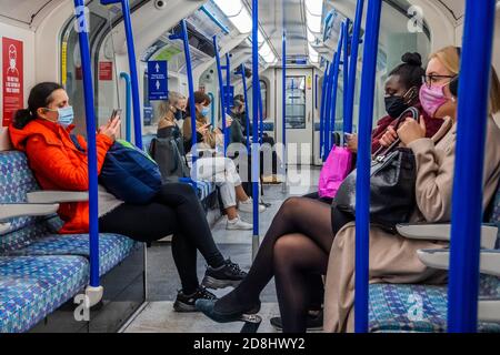 Londres, Royaume-Uni. 30 octobre 2020. Certains ignorent encore les signaux d'avertissement autour ou au-dessus d'eux - les numéros de passagers restent bas sur le métro, mais sont maintenant en hausse et les trains sont modérément occupés. Tout comme le gouvernement commence à resserrer ses directives sur le coronavirus (Covid 19). Ceux qui voyagent portent surtout des masques après qu'ils sont devenus obligatoires dans les transports publics. Crédit : Guy Bell/Alay Live News Banque D'Images