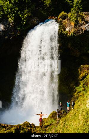 Un observateur exubérant des chutes d'eau se tient près des chutes Sahalie, sur la rivière McKenzie, en Oregon. Banque D'Images