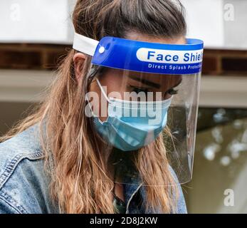 Un coiffeur mobile indépendant s'occupe de l'un des cheveux de son client dans le jardin arrière pendant la pandémie de Covid 19 ou de Covid 19 en Angleterre. Banque D'Images