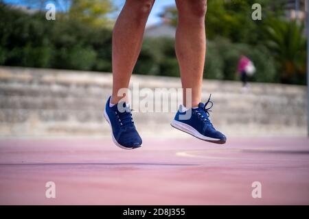 Détail d'un homme formant ses jambes avec des fentes de puissance dans un parc à l'extérieur Banque D'Images