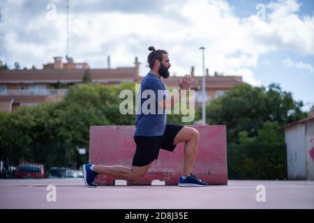 L'homme forme ses jambes avec des fentes de puissance dans un parc à l'extérieur Banque D'Images