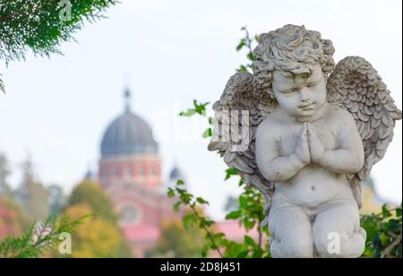 Sculpture d'un petit ange sur une tombe dans un cimetière. Mise au point sélective Banque D'Images