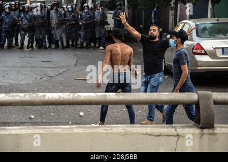 Beyrouth, Liban, 30 octobre 2020. Un homme tente d'empêcher les gens de jeter des pierres sur la police, car un petit groupe d'hommes de Tripoli et de Beyrouth s'opposent aux forces de sécurité intérieures libanaises. Des écueils ont éclaté alors que le groupe pan-islamique Hizb UT Tahrir a tenté de se rendre à l'ambassade de France pour protester contre ce qu'ils considèrent comme la position anti-islamique du président Emmanuel Macron. Les émotions ont couru haut comme il a été senti le prophète Mohammed est en train d'être mérespecté pendant son mois d'anniversaire. Crédit : Elizabeth FITT/Alay Live News Banque D'Images