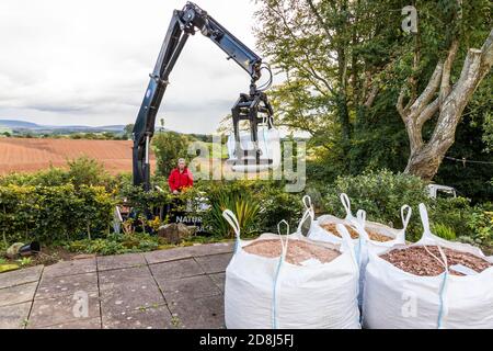 Gros sacs de gravier livrés par une grue de camion à une propriété domestique dans le village d'Irthington, Cumbria UK Banque D'Images