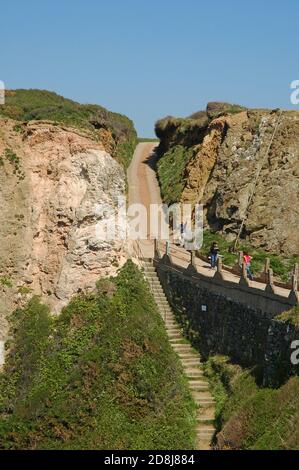 Partie de la Coupée, vue de Little Sark à Sark, montrant les marches menant à la Grande Greve, la plage de sable en contrebas. Banque D'Images